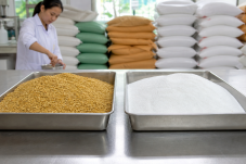 Khô đậu tương và axit amin tổng hợp trong khay nguyên liệu tại xưởng trộn thức ăn, minh họa việc giảm protein thô